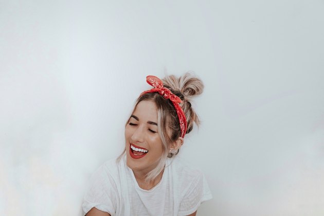 woman smiling in front of white wall