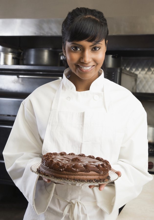 Female pastry chef holding cake